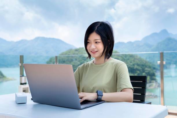 istock An Asian female freelancer using a laptop to work outdoors in the journey 1271653507