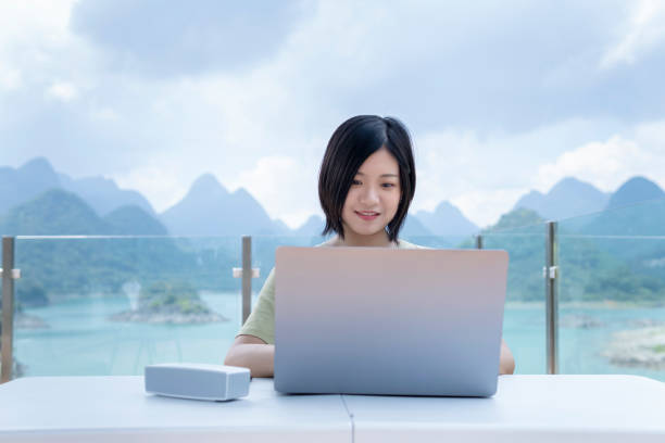 istock An Asian female freelancer using a laptop to work outdoors in the journey 1271653524