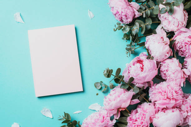 istock Feminine workspace with notebook, pink peony, eucalyptus flower on blue background. Top view, copy space. Blogger, feminine business concept. Flat lay. Birthday, Woman day. Mock up 1271654552