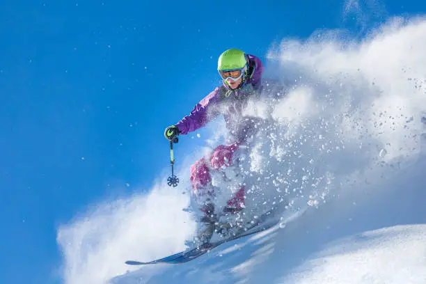 Young woman jumping over the fresh powder snow