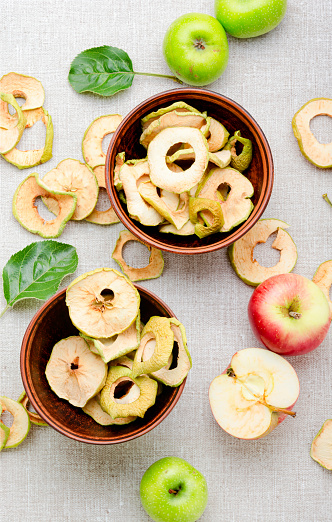 Sun-dried apple slices or apple chips and fresh apple.Dehydrated apples chips