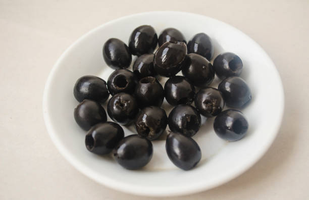 istock Pitted black olives on a white plate. 1271655966