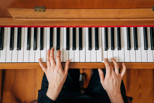 istock Woman practicing upright piano at home 1271666442