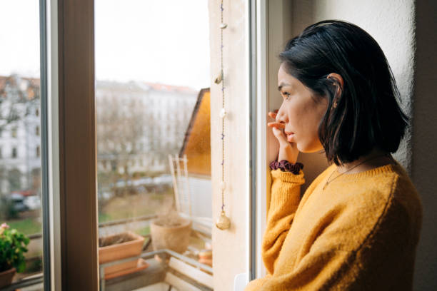 istock Contemplated woman looking through window 1271666671