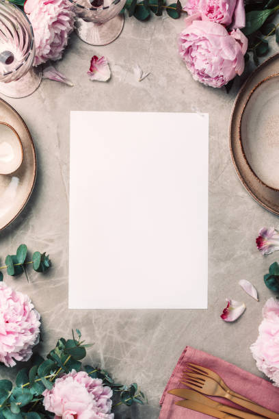 istock Flat lay composition with peony, eucalyptus flowers, empty plates, napkin, golden cutlery, wineglasses for serving a festive table, dinner on marble background. Copy space. Top view. Table setting 1271666849