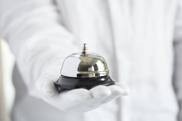 istock First-class service. Hand in white gloves holding hotel bell 1271667424