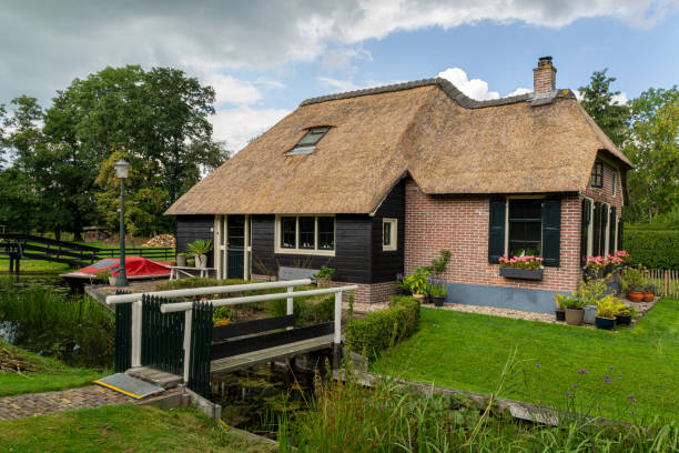 Giethoorn, The Netherlands - August 28, 2020: Bridge in front of a house with thatched roof