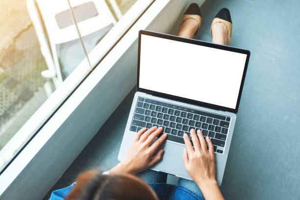 istock a businesswoman using and typing on laptop computer with blank white desktop screen while sitting on the floor 1271670829