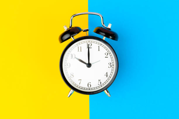 istock Black alarm clock on color block yellow and blue background 1271671759