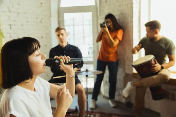 Photo of Musician band jamming together in art workplace with instruments