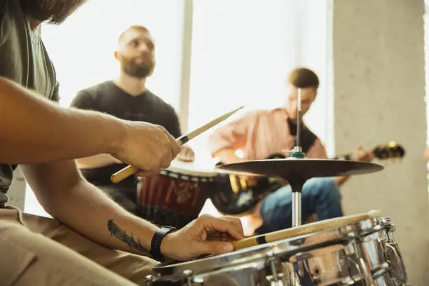 Photo of Musician band jamming together in art workplace with instruments