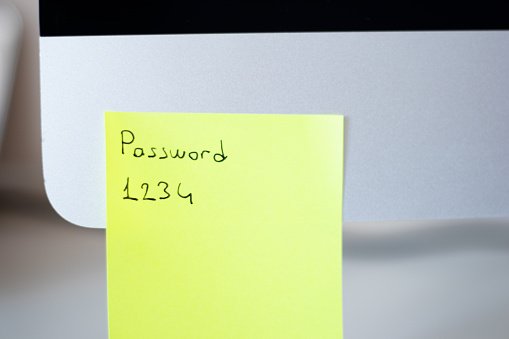 Password written sticky paper on computer. Horizontal composition with copy space.