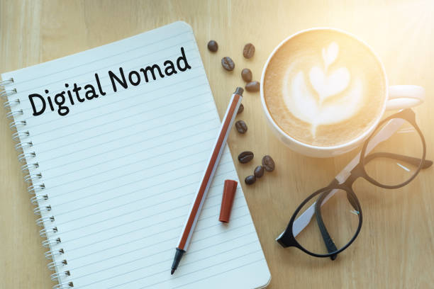 istock Concept digital nomad on notebook with glasses, pencil and coffee cup on wooden table.  Sunlight in the morning. 1271677844