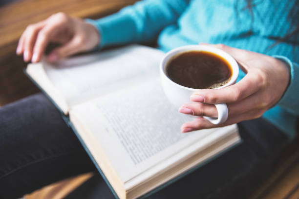 istock woman hand coffee with book 1271677936