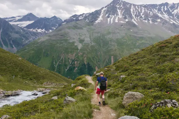 July 21, 2020 - Rifflsee, Austria: fit man hiking high up in the mountains in Austria- getting away from Covid and pandemics, being free and having adventures.