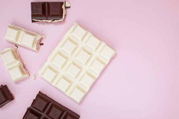 istock White and black chocolate bars and pieces on pink background, top view 1271678525