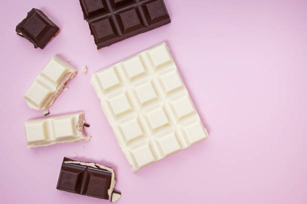 istock White and black chocolate bars and pieces on pink background, top view 1271678532