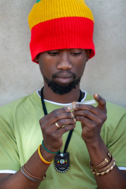 istock African rastafarian man preparing to roll a joint and smoke 1271680744