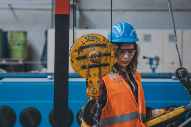 istock Young engineer woman holding and working with remote control for operating crane 1271680973