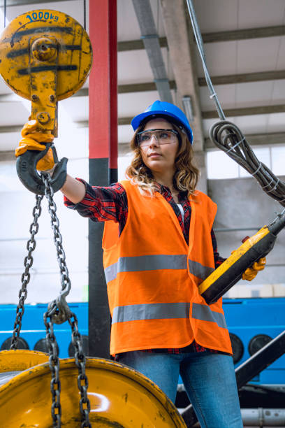 istock Young engineer woman holding and working with remote control for operating crane 1271681025
