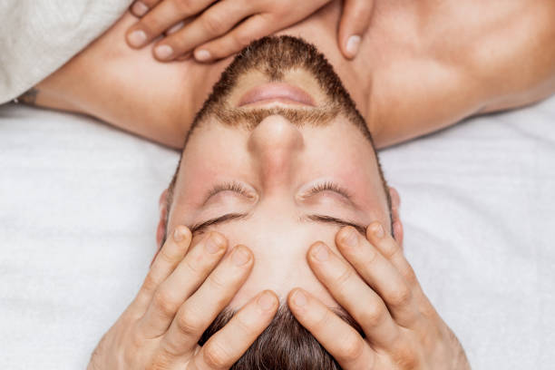 istock Man receiving head massage by two masseurs 1271681639