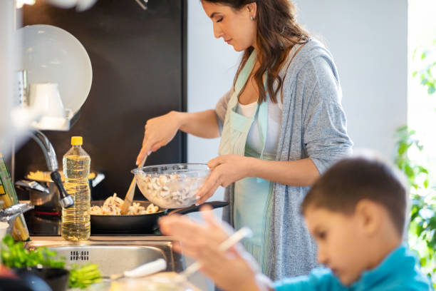 istock Boy helping mother in the kitchen by the counter 1271685280
