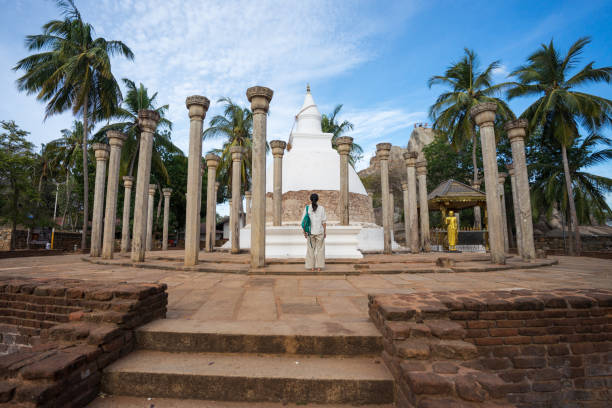 Young Asian tourist in front of Ambasthala Dagaba stupa with columns in Mihintale Buddhist temple Mihintale / Sri Lanka - August 10, 2019: Young Asian tourist in front of Ambasthala Dagaba stupa with columns in Mihintale Buddhist temple mihintale stock pictures, royalty-free photos & images