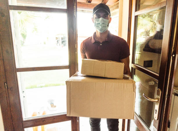 istock messenger delivering a box during the covid19 1271686542