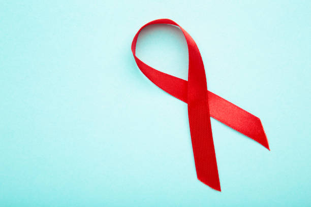 istock Aids awareness red ribbon on blue background 1271687519