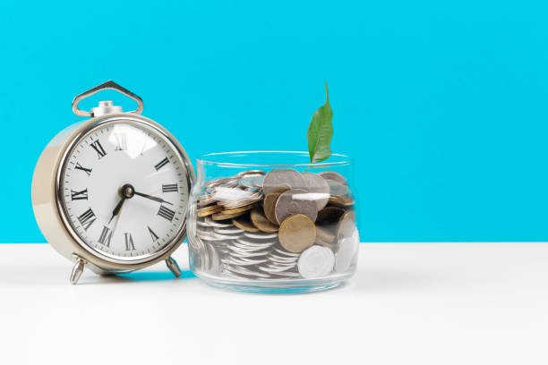 istock Alarm clock and money coins on the table. 1271688219