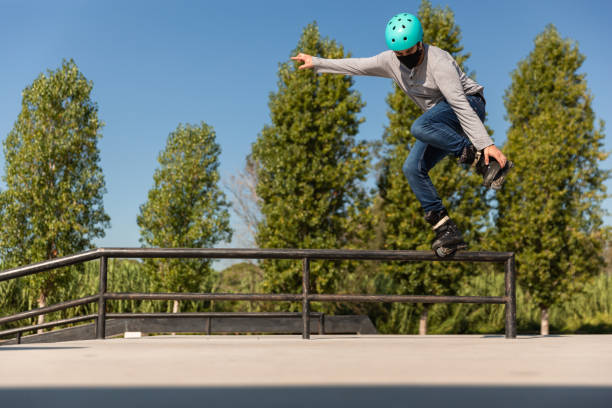 istock male roller skater with protective helmet and coronavirus prevention mask does a trick in a skate park 1271689026