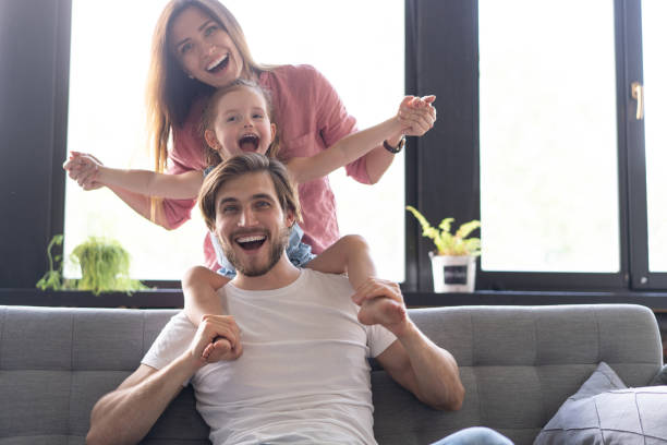 istock Happy cheerful parents having fun with cute children daughters playing on sofa 1271689064