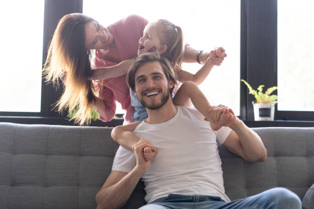 istock Happy cheerful parents having fun with cute children daughters playing on sofa 1271689066