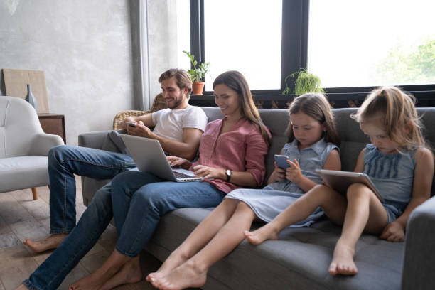 istock Modern family values. Father, mother and daughters using electronic devices 1271689090
