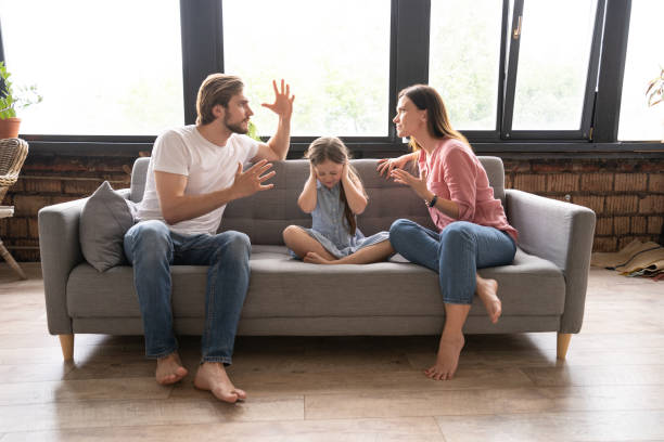 istock Little girl between arguing parents at home. 1271689572