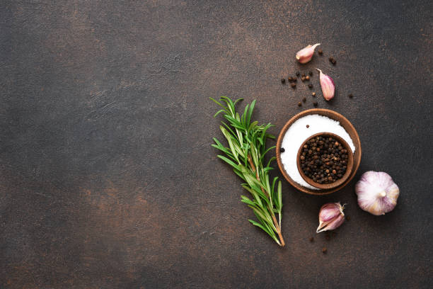 istock Peppercorns, garlic and fresh rosemary on a concrete background. 1271689743