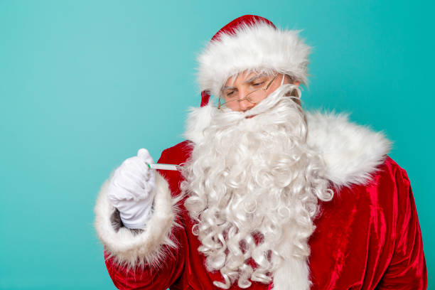 istock Santa Claus having fever measuring temperature using thermometer 1271694670