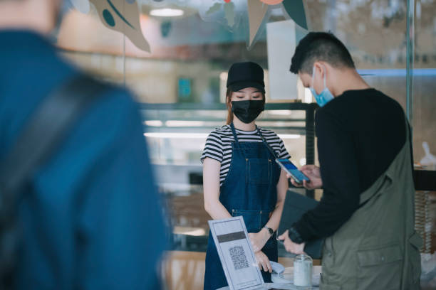 istock asian chinese cafe waitress checking body temperature for client as standard procedure and check in process before entering cafe as new normal 1271696042