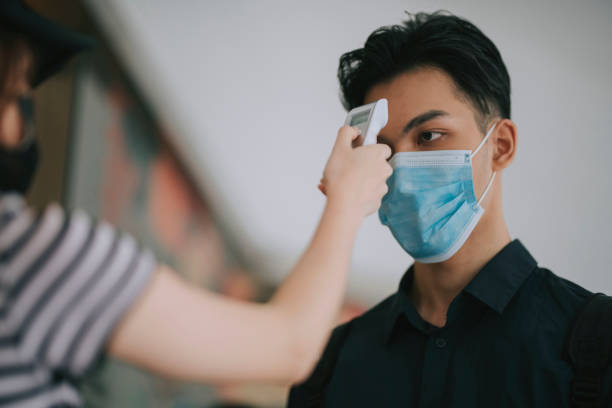 istock asian chinese cafe waitress checking body temperature for client as standard procedure and check in process before entering cafe as new normal 1271696077