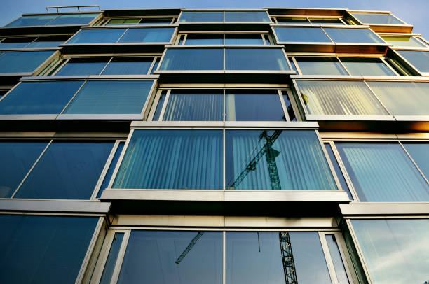istock glass office building blue architecture office district mirrored reflection crane machine 1271696214