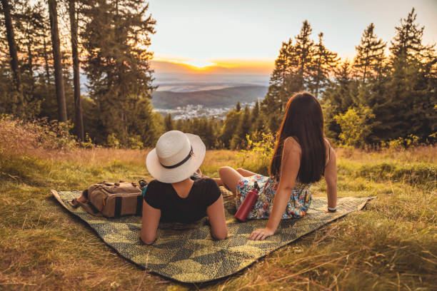 Two Young Happy Girls on Picnic, Laughing, Drinking water, Having Fun