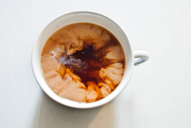 Milk creating cool effect in the tea when poured in the cup