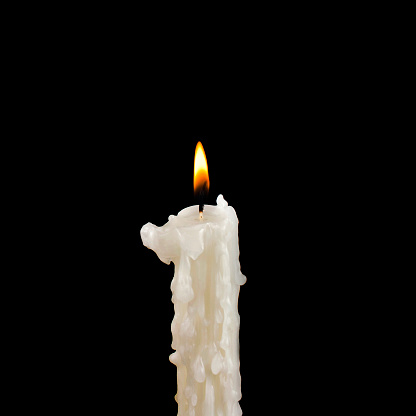 Burning candle on a black background.