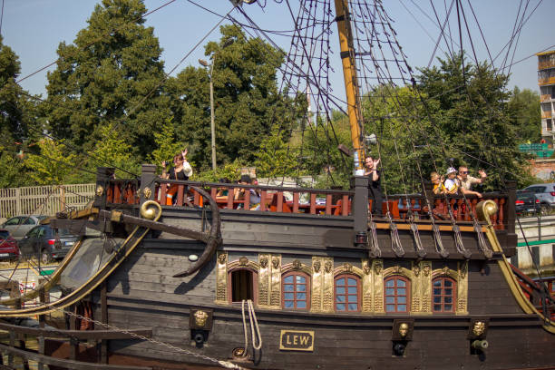 close-up de navio pirata e passageiro acenando para outro navio navegando sobre o rio motlawa depois que máscaras não eram obrigatórias para usar ao ar livre durante o tempo covid - naval flag - fotografias e filmes do acervo