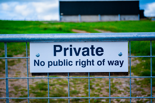 Private sign no public right of way on a farm with a view of a field