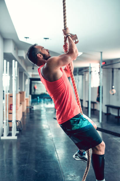 istock Male Athlete Practicing Rope Climbing In Gym 1271706682