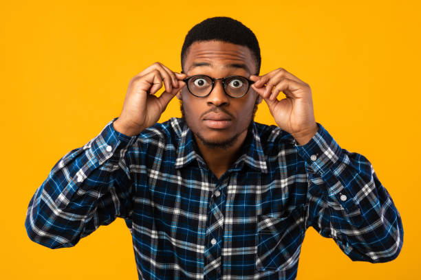 istock Amazed African American Looking At Camera Through Eyeglasses, Yellow Background 1271707534