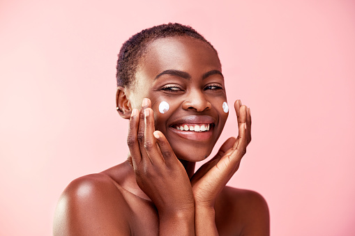 Studio shot of a beautiful young woman posing against a pink background