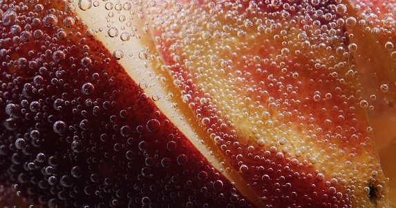Sliced fresh peach in soda water. Extreme close-up