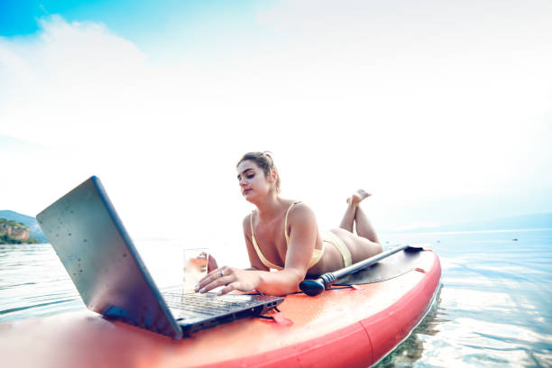 istock Female Relaxing With Waterproof Laptop While Paddle boarding 1271709221